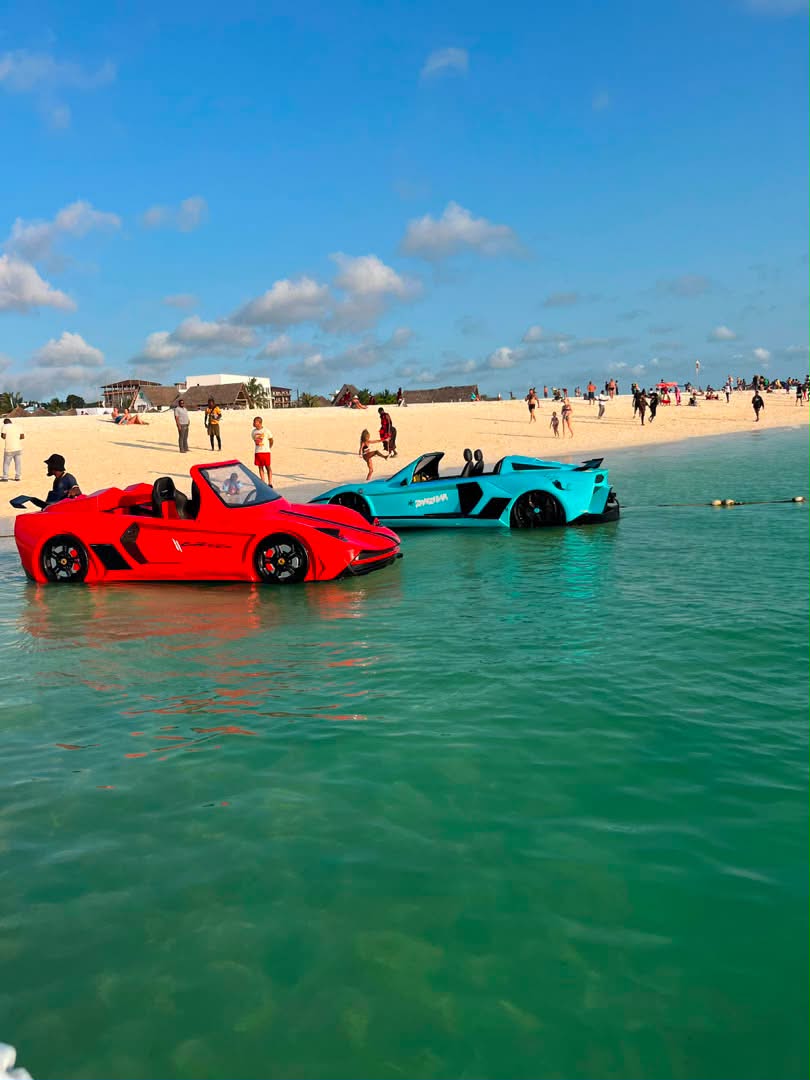Bright red and blue jet cars in turquoise ocean water at a tropical beach
