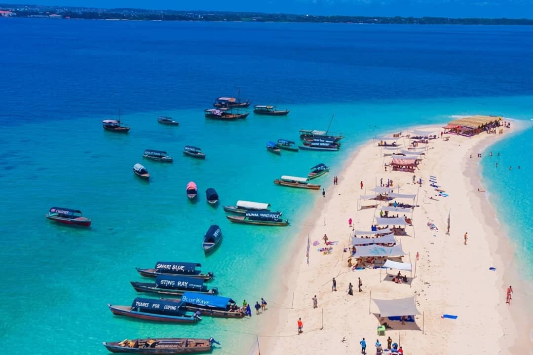 Aerial view of Nakupenda sandbank with boats on turquoise water and white sand